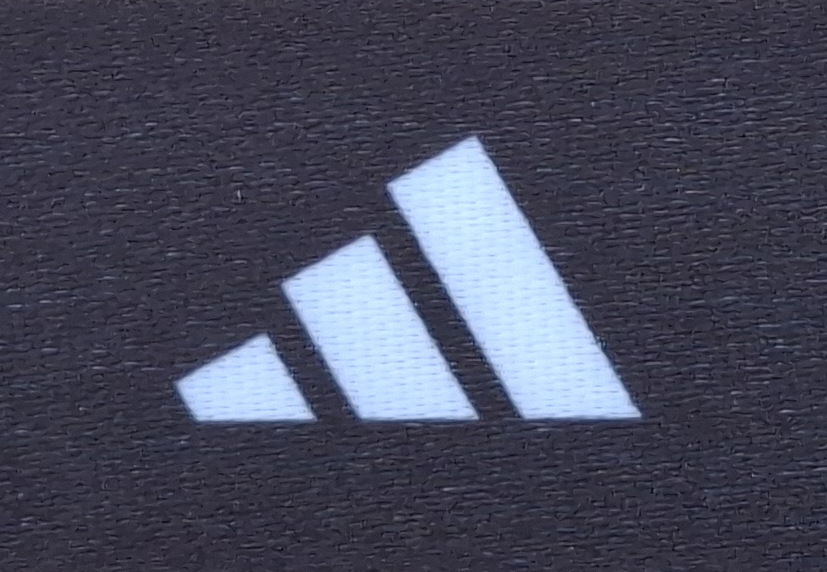Adidas logo with three parallel stripes on a black background.