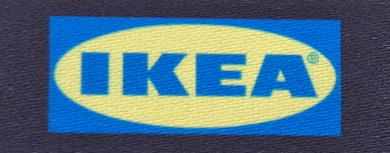 IKEA logo, yellow and blue with the lettering "IKEA" in large letters on a textured background.